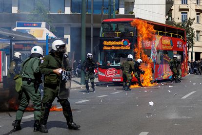 Un cóctel molotov impacta contra un autobús turístico en el centro de Atenas durante las protestas de este domingo.  