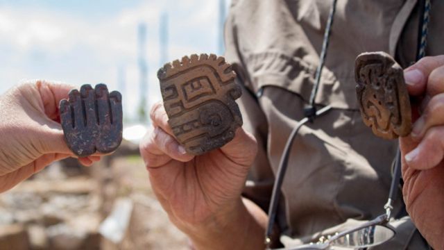 Los arqueólogos muestran algunas piezas halladas en la tumba.