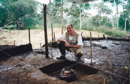 El arqueólogo Stéphen Rostain posa junto a una jarra de cerámica para cerveza dulce de maíz (chicha), durante una excavación arqueológica en el Valle del Upano.