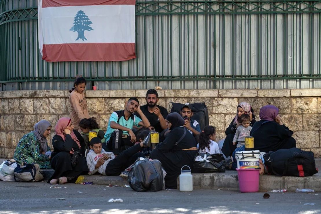 Los desplazados internos se sientan bajo una bandera libanesa en el barrio de Dahieh el 28 de septiembre de 2024 en Beirut, Líbano. Crédito: Carl Court/Getty Images.