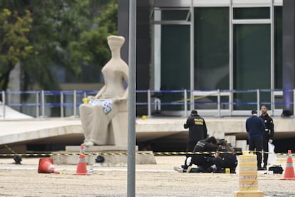 Policías inspeccionan el cadáver del bolsonarista que se hizo estallar frente a la Suprema Corte, este 14 de noviembre en la capital brasileña.