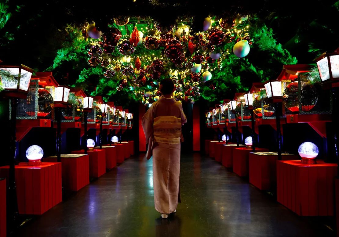 Un visitante observa una instalación navideña con peces de colores y luces de colores en el Museo del Acuario de Arte de Tokio.