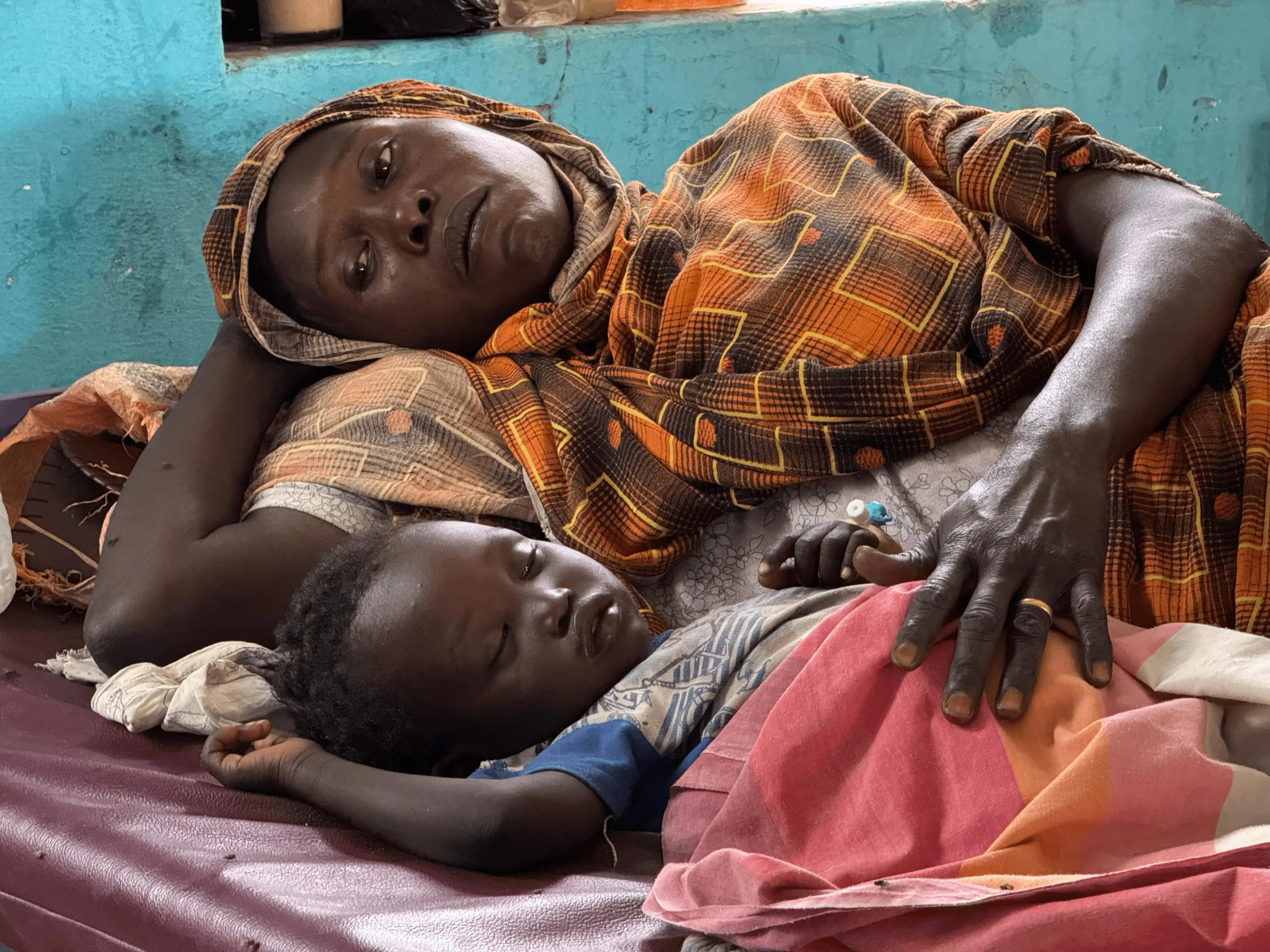 Una madre y su hijo en la sección pediátrica del centro de tratamiento del cólera de Kosti, en el estado de Nilo Blanco. Sudán, marzo de 2025.