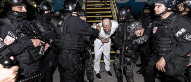 Deportado desde Estados Unidos llegando a El Salvador y siendo trasladado por policías al Centro de de Confinamiento de Terrorismo (CECOT).