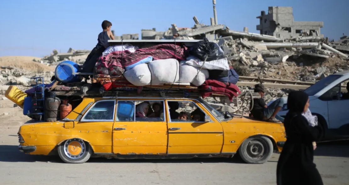 Los palestinos desplazados se mueven hacia el sur con sus pertenencias por una carretera en el campamento central de Gaza, después de que Israel renovara las órdenes de evacuación para la ciudad de Gaza el 16 de septiembre.