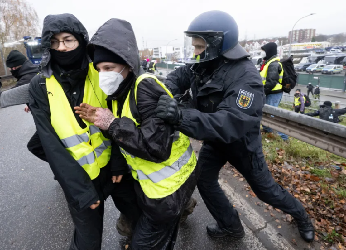 Un agente de la policía federal empuja a los manifestantes fuera de una calle el sábado, en medio de una protesta contra la fundación de una nueva organización juvenil de la AfD en Giessen, Alemania.
